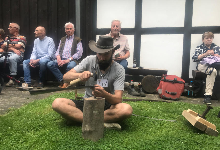 Konzentration und ein gutes Auge helfen beim Dengeln des Sensenblattes. Foto: Heimatverein Leopoldshöhe