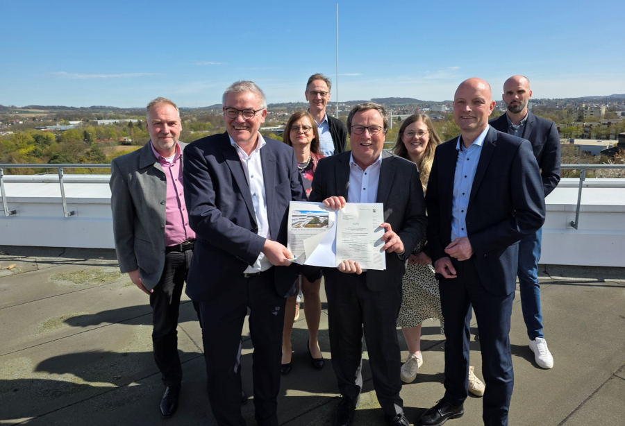 Umweltminister Oliver Krischer (Mitte) und Jens Kronsbein, Leiter der Abteilung Regionale Entwicklung bei der BezReg (rechts), überreichen Rainer Grabbe (links) und dem Projektteam beim Kreis Lippe den Förderbescheid für die Umsetzung der klimaangepassten Außenanlagen am Kreishaus. Foto: Kreis Lippe