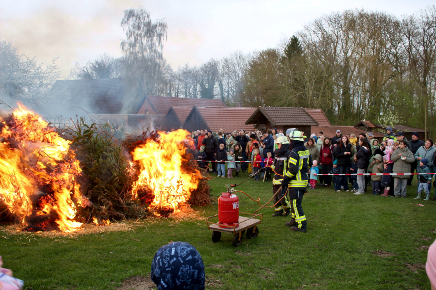 Zwei Feuerwehrleute fachten das Osterfeuer des Heimatvereins auf dem Heimathof an. Foto: Thomas Dohna
