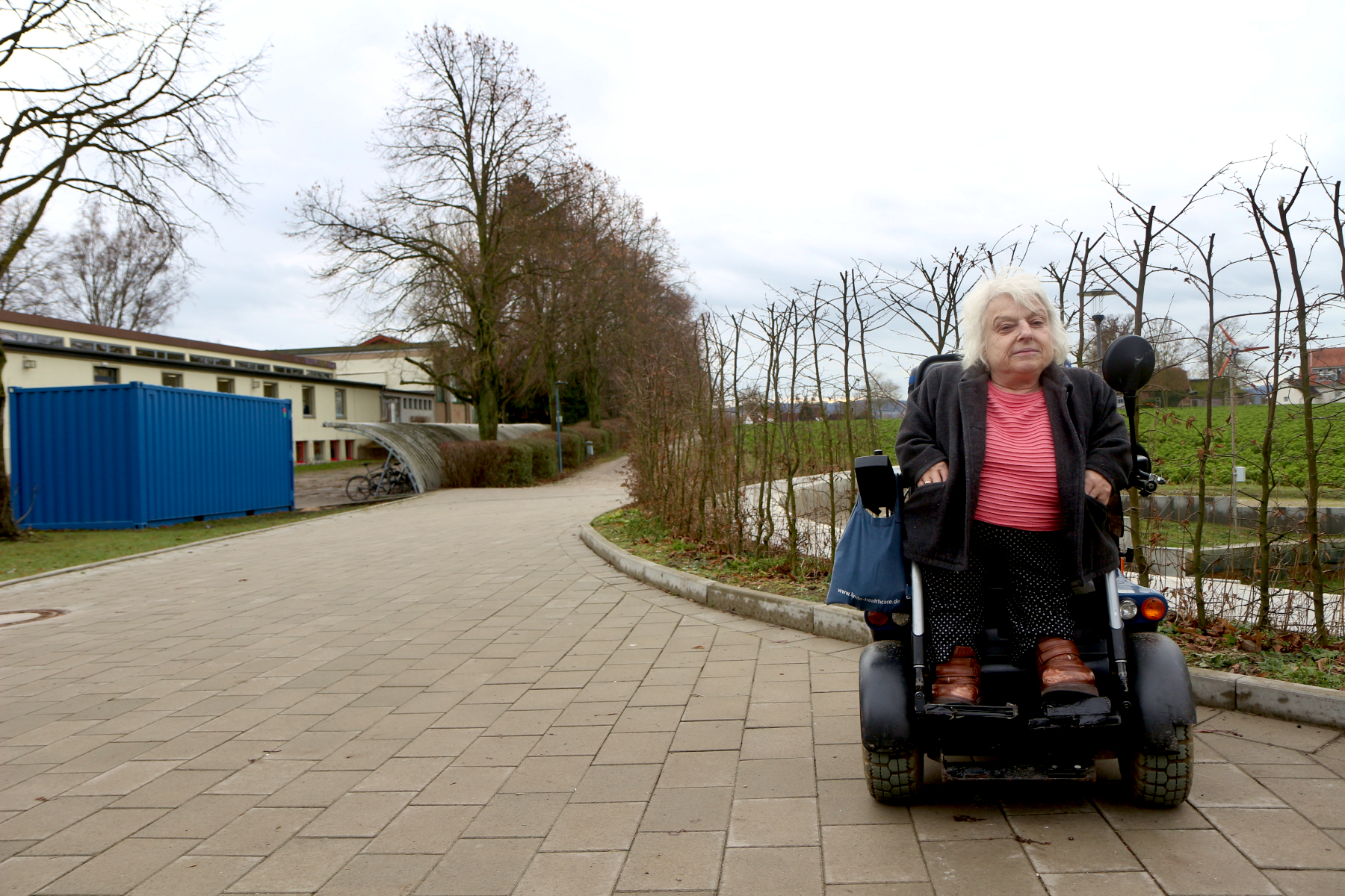 Die Behindertenbeauftragte der Gemeinde Beate Twittenhoff wünscht sich einen Behindertenparkplatz am multifunktionalen Anbau der FFG etwa dort, wo im Winter der blaue Container stand. Foto: Thomas Dohna