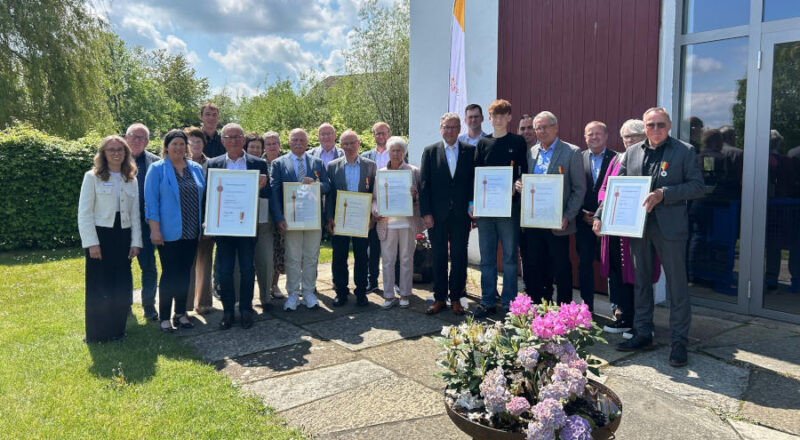 Landrat Meinolf Haase (Mitte), Nicole Plugge (dritte von links) und einige Bürgermeister (zweite Reihe, Mitte und rechts) freuen sich zusammen mit den Preisträgerinnen und Preisträgern des diesjährigen Lippischen Ehrenrings. Foto: Kreis Lippe