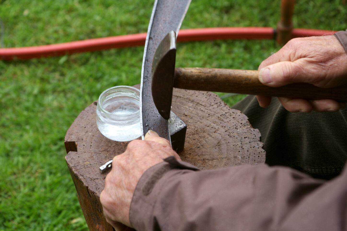 Mit dem spitzen Hammer wird das Sensenblatt auf dem flachen Amboss scharf geklopft. Foto: Thomas Dohna