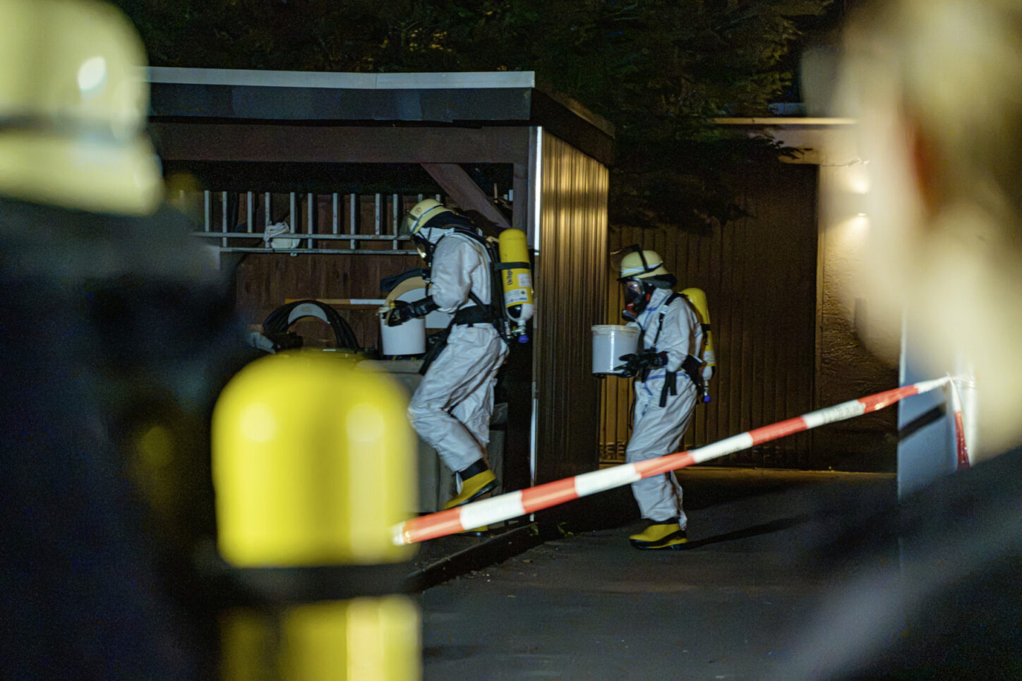 Die Einsatzkräfte tragen die Eimer mit dem Wühlmausgift zum den hinteren Teil des Grundstückes. Foto: Die Blaulichtfotografen