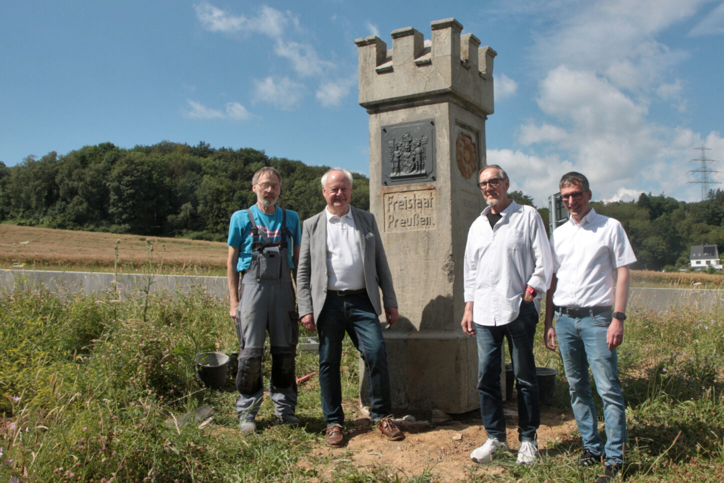 Steinmetz Karsten Sümnich, Manfred Burkamp, Hauptsponsor Hans-Jürgen Laufer und Bürgermeister Martin Hoffmann stehen am Grenzstein. Foto: Thomas Dohna