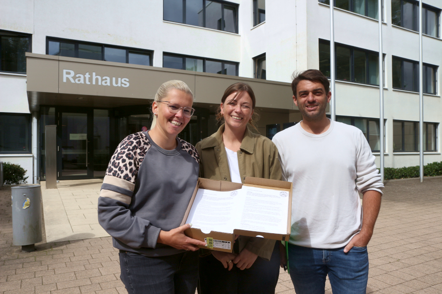 Mareike Loges, Annelie Kerker und Tobias Schilling werden gleich die Unterschriftenlisten für das Bürgerbegehren im Rathais abgeben, mit dem sie den Erhalt der kommunalen Kitas erreichen wollen. Foto: Thomas Dohna