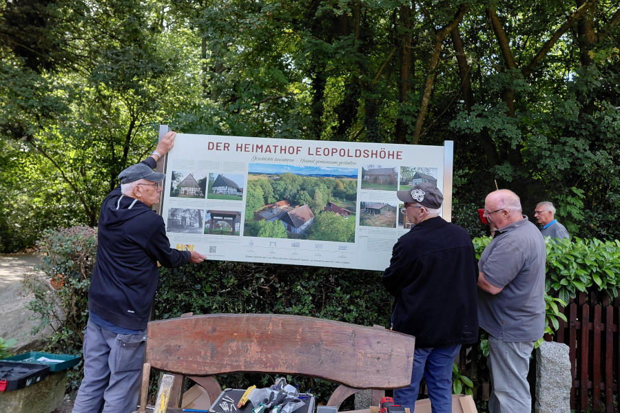 Die Männer von der Dienstagsgruppe stellen die neue Infotafel am Heimathof auf. Foto: Heimatverein Leopoldshöhe