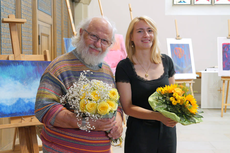 Kantorin Leonie Deutschmann und Künstler Wolfgang H. Schmutz inmitten seiner Bilder. Foto: Lippische Landeskirche
