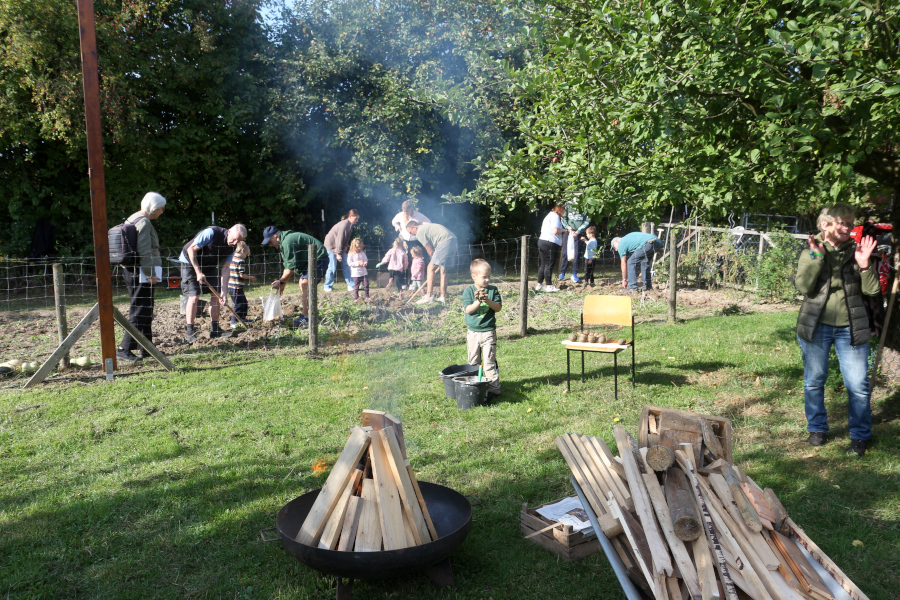 Hinten ernten Kinder Kartoffeln, die sie über dem Feuer vorne garen können. Foto: Thomas Dohna
