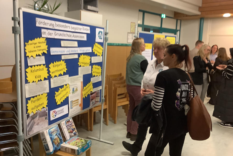 Lehrerin Birgit Nabben (zweite von rechts) erklärt einer Interessentin anhand der Schautafel die Begabtenförderung an der Grundschule Asemissen. Foto: GS Asemissen